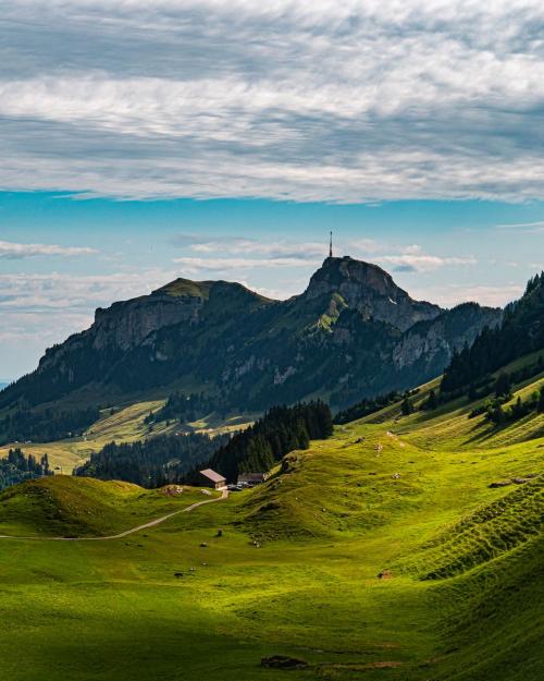 Breathtaking view of lush green valleys and mountains in Sennwald, Switzerland.
