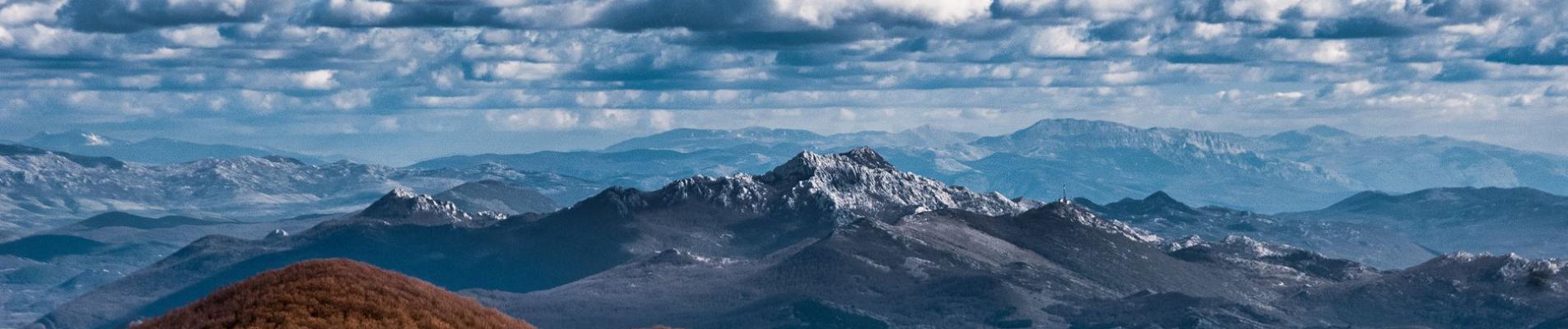 Beautiful view of the Velebit Mountains in Croatia under a dynamic cloudy sky, capturing the essence of nature.
