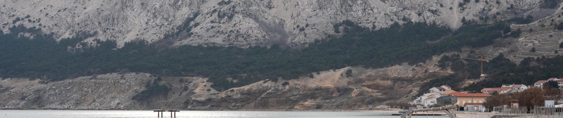 Explore the tranquil beauty of Baska Beach in Krk, Croatia, with mountains and coastal scenery.
