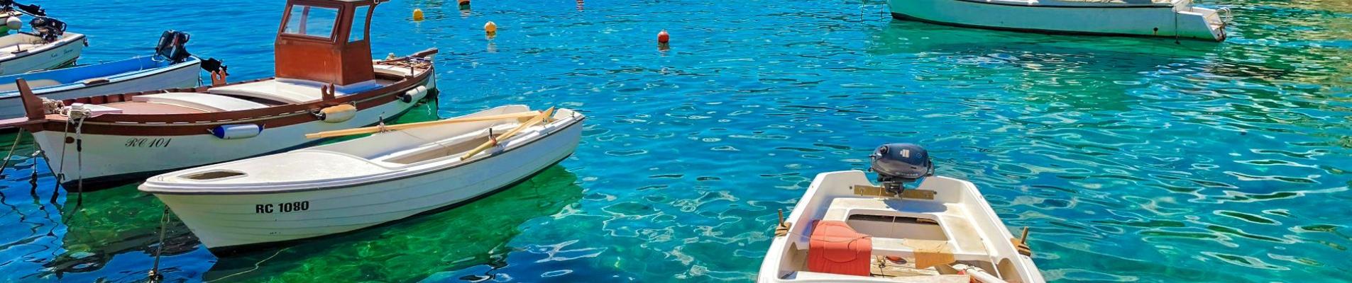 Idyllic view of boats floating in clear turquoise waters of Kvarner Bay, Croatia under a bright summer sky.