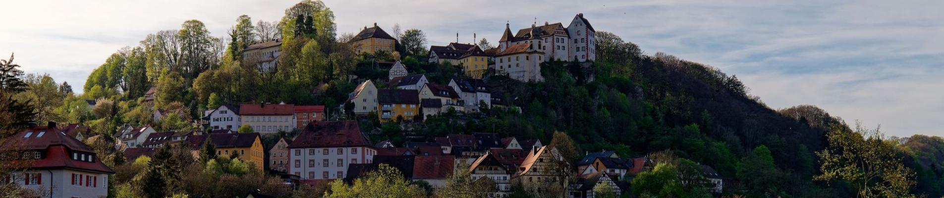Picturesque hillside village of Egloffstein in Bavaria, Germany, surrounded by lush greenery.
