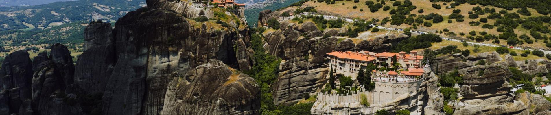 Stunning aerial shot of Meteora monasteries perched on rocky cliffs in Greece's landscape.