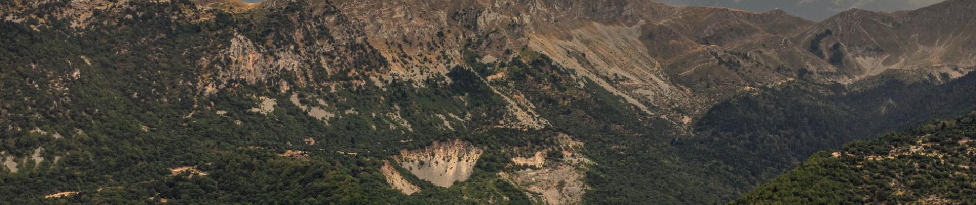 Stunning aerial view of rugged Pindus Mountains under a cloudy sky in Greece.