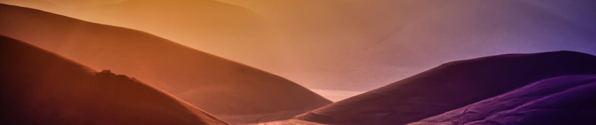 Dramatic landscape of sunset over Montemonaco's hilly terrain, showcasing vibrant natural beauty.