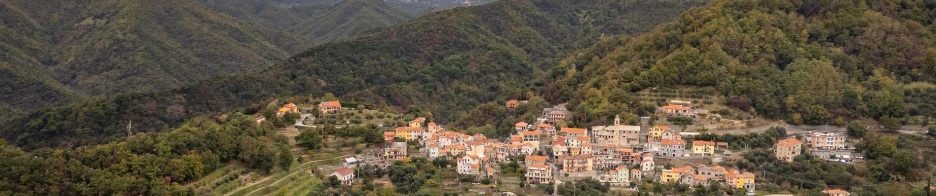 Aerial view of a charming village in the lush green hills of Gameragna, Liguria, Italy.