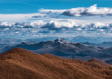 Beautiful view of the Velebit Mountains in Croatia under a dynamic cloudy sky, capturing the essence of nature.