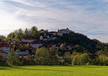 Picturesque hillside village of Egloffstein in Bavaria, Germany, surrounded by lush greenery.
