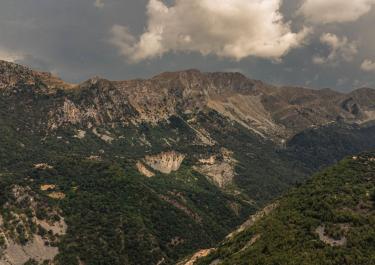 Stunning aerial view of rugged Pindus Mountains under a cloudy sky in Greece.